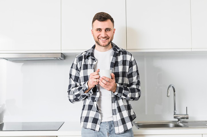 portrait-smiling-young-man-holding-cup-hand-looking-camera_23-2148137560